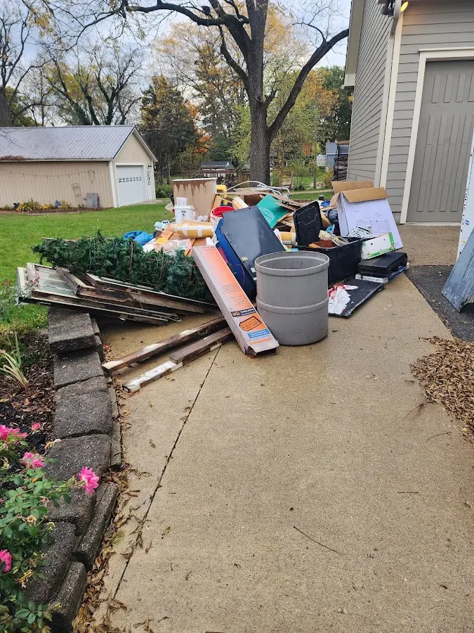 Dumpster being loaded with debris for Estate Cleanout Dumpster Rental in Imlay City